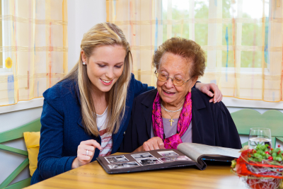 caregiver and senior looking at the album